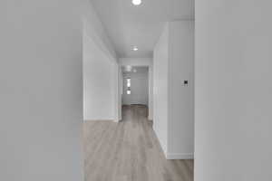 Hall featuring light wood-type flooring, recessed lighting, and baseboards