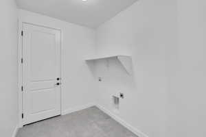 Washroom with hookup for a washing machine, hookup for an electric dryer, and baseboards
