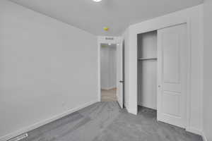 Unfurnished bedroom with carpet flooring, baseboards, and a closet