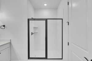Bathroom featuring vanity, a shower stall, and recessed lighting
