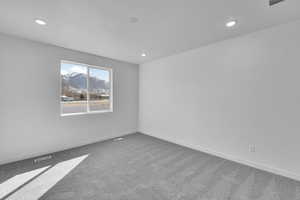Carpeted empty room featuring recessed lighting and baseboards