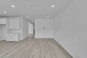 Unfurnished living room featuring recessed lighting, baseboards, and light wood-style floors