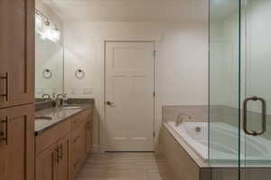 Full bath featuring double vanity and a garden tub