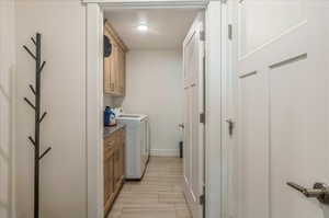 Laundry room with cabinet space, separate washer and dryer, baseboards, and a textured ceiling
