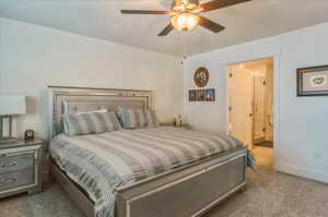 Bedroom featuring carpet floors, ensuite bath, a ceiling fan, and baseboards