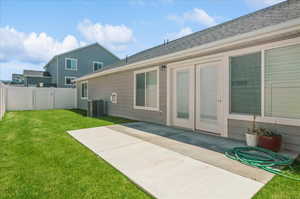 Back of house featuring central AC, a patio area, and roof with shingles