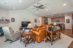 Living area with recessed lighting, a ceiling fan, vaulted ceiling, wood finished floors, and baseboards