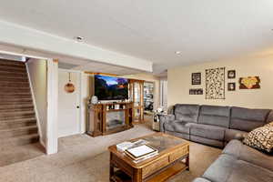 Carpeted living area featuring stairs