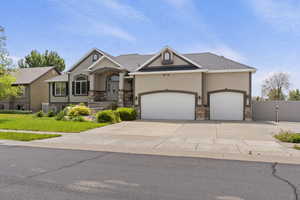 View of front of property featuring stucco siding, a garage, driveway, and a gate