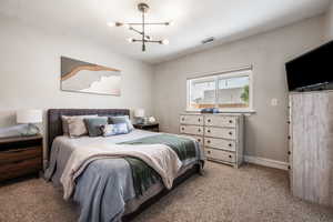 Bedroom featuring a chandelier and light colored carpet