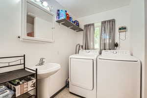 Laundry room featuring washing machine and dryer and light tile patterned floors