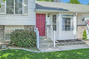 Property entrance with brick siding and a shingled roof