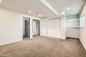 Unfurnished bedroom featuring carpet floors, recessed lighting, baseboards, and multiple closets