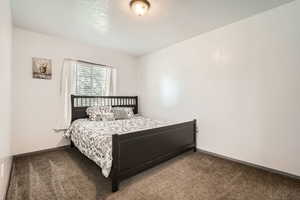 Bedroom with carpet and a textured ceiling