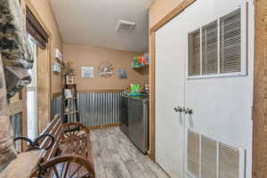 Washroom featuring a heating unit, wood finished floors, and washer and dryer