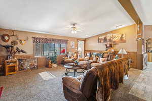 Living area with a ceiling fan and wainscoting