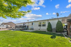 Rear view of house with a patio, a yard, a wooden deck, and central air condition unit
