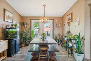 Dining area with wood finished floors and a chandelier