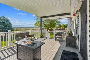 Wooden deck featuring a fire pit and a yard