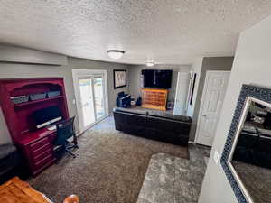 Carpeted living room with a textured ceiling and tile patterned flooring