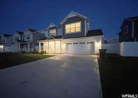 View of front of home featuring concrete driveway, a garage, and a residential view