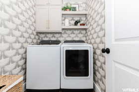 Laundry area with cabinet space and washing machine and clothes dryer