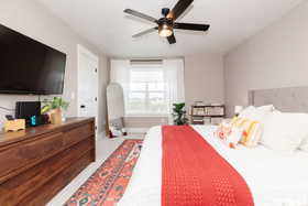 Carpeted bedroom featuring a ceiling fan and baseboards