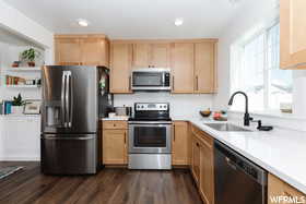 Kitchen featuring stainless steel appliances, a sink, light countertops, and recessed lighting
