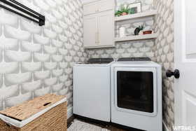 Laundry area with cabinet space, separate washer and dryer, and dark wood-style floors