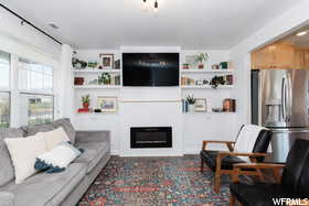 Living room with a glass covered fireplace and built in shelves