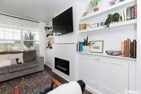 Living area featuring dark wood-style floors, a fireplace, and built in features