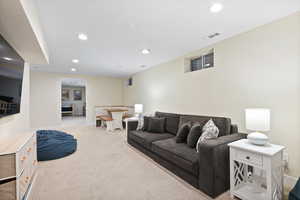 Living room featuring light carpet, recessed lighting, and baseboards
