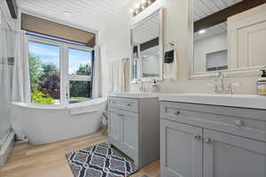 Full bathroom with vanity, wood finished floors, wooden ceiling with exposed beams, a soaking tub, and recessed lighting