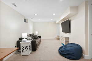 Living room with light carpet, recessed lighting, baseboards, and stairs