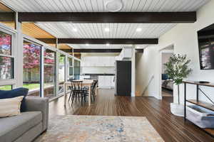 Dining area featuring dark wood-style flooring, baseboards, wood ceiling with exposed beams, and recessed lighting