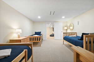 Bedroom featuring light carpet, recessed lighting, baseboards, and a textured ceiling