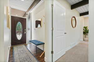 Entryway featuring wood ceiling with exposed beams, baseboards, and recessed lighting