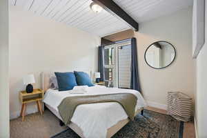 Bedroom featuring beam ceiling, baseboards, and carpet flooring