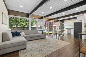 Living area with beamed ceiling, dark wood finished floors, and recessed lighting