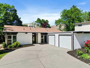 View of front of property with concrete driveway, an attached garage, and roof with shingles
