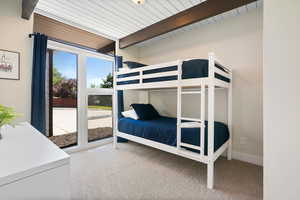Carpeted bedroom with beam ceiling
