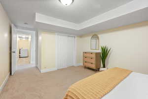 Bedroom featuring carpet floors, a closet, a textured ceiling, and baseboards