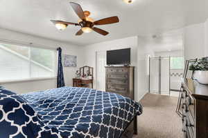 Carpeted bedroom with a ceiling fan
