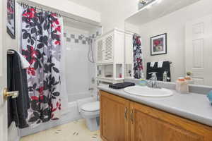 Full bathroom featuring vanity, shower / tub combo with curtain, and toilet