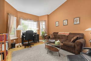 Office with wood finished floors, lofted ceiling, and baseboards