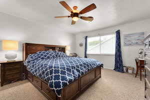 Bedroom featuring light colored carpet, ceiling fan, and baseboards