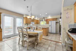Dining area featuring light tile patterned floors, a chandelier, and recessed lighting