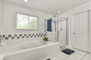 Bathroom with a whirlpool tub, tile patterned flooring, a shower stall, and recessed lighting
