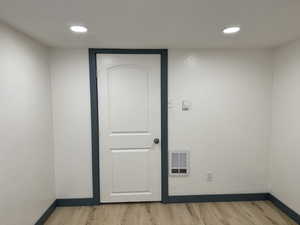 Spare room featuring light wood-style floors, baseboards, and recessed lighting
