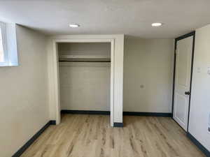 Unfurnished bedroom with light wood finished floors, baseboards, and a closet